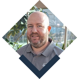 photo of Ode Custom Renovations Managing Partner, David Rhoades, framed in a diamond cutout with a stylized thicker bottom portion in navy blue